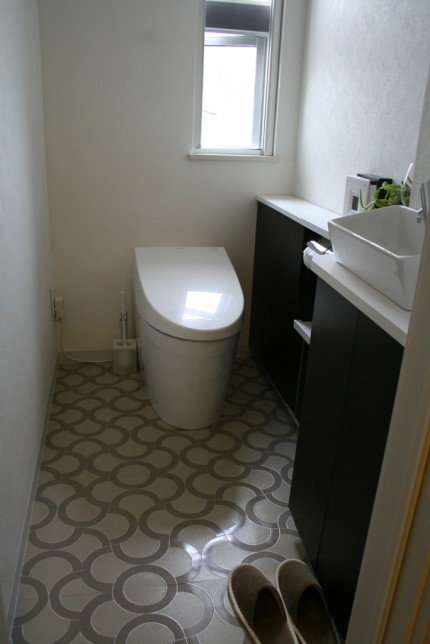 シックなデザインのシェルフのある住宅のトイレ。