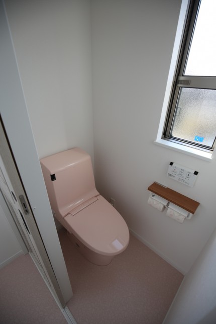 可愛いピンクの便座を設置した住宅のトイレ。
