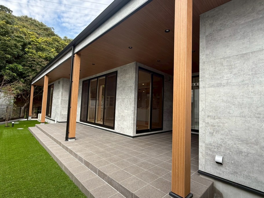 グレーのタイルデッキと木目屋根が調和する中庭