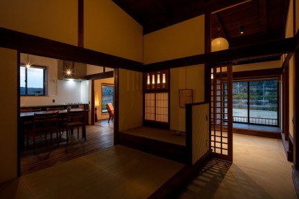 夜のダイニングと畳の間。照明が木や畳を照らし出し、温かく心地よい雰囲気に包まれています。